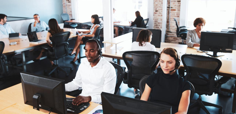 Open plan office with call centre employees in front of laptops