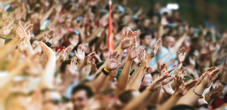 Crowd of people at a convention with arms outstretched