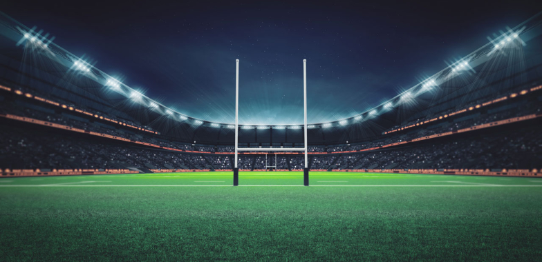 Rugby goal posts in a stadium lit up at night