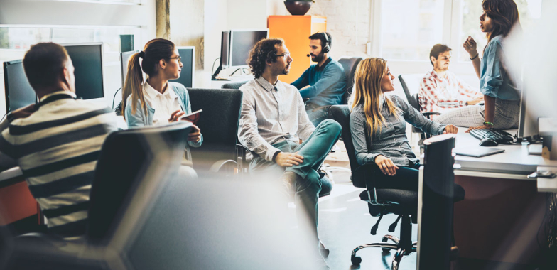 Group of office workers in office sitting on chairs talking